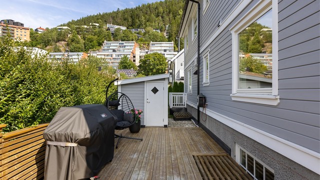 Ved enden av terrassen er det en frittstående bod, perfekt til lagring av uteputene