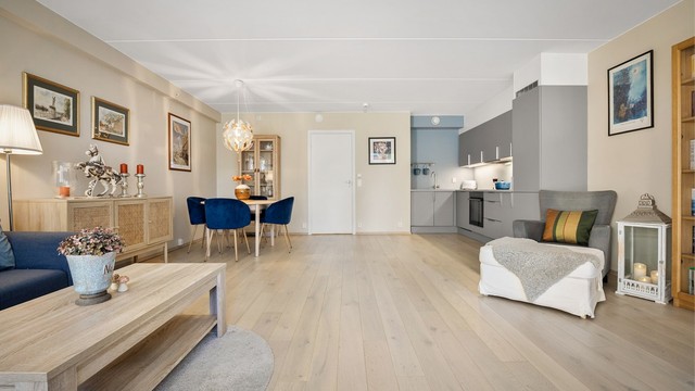 Åpen kjøkken- og stueløsning med sofaområde samt spiseplass.