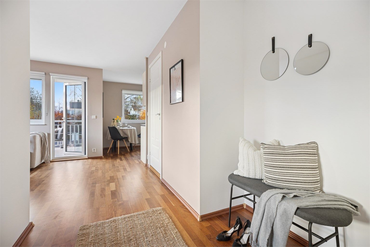 Den innbydende entréen åpner opp mot en stilren stue badet i naturlig lys – et gjennomført og moderne hjem.