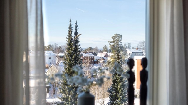 Fra vinduene har man en åpen og grønn utsikt over et rolig boligområde.