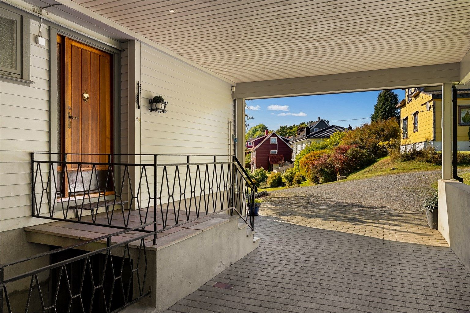 Fra carporten er det kort vei til både hovedinngangen og kjellertrappen.