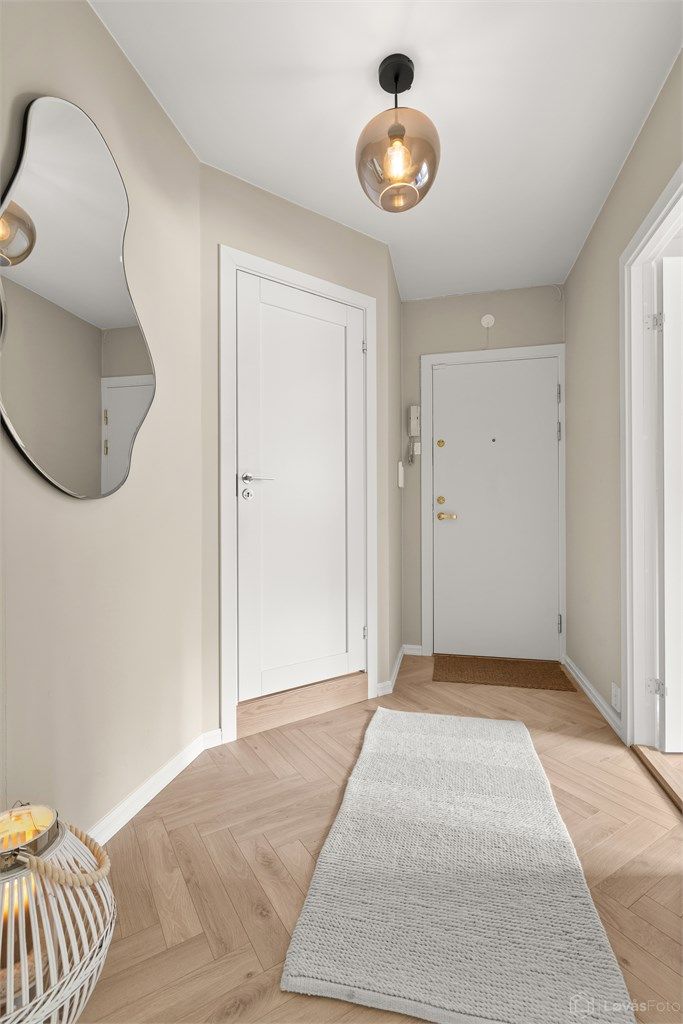 Lys og innbydende entré/gang med 1-stavs fiskebenslaminat. Dørcalling anlegg til felles inngangsparti