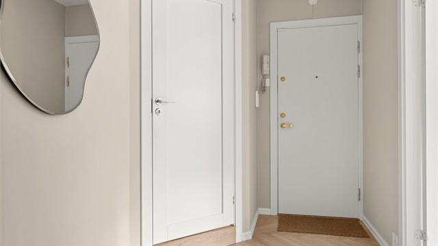 Lys og innbydende entré/gang med 1-stavs fiskebenslaminat. Dørcalling anlegg til felles inngangsparti