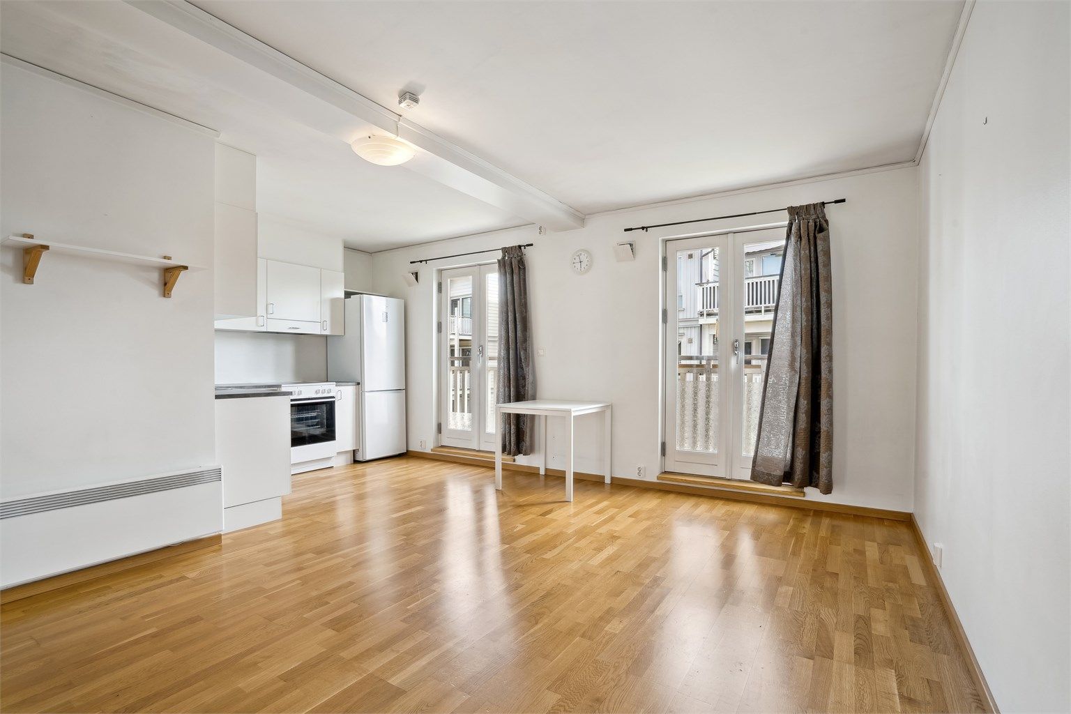 Stue og kjøkken i åpen løsning med to sjarmerende franske balkonger