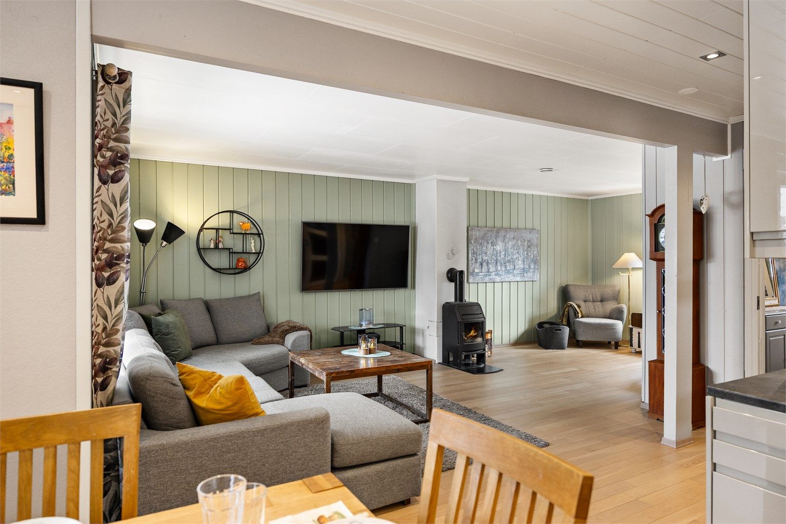 Den åpne løsningen mellom stue og kjøkken skaper en sosial og innbydende atmosfære.