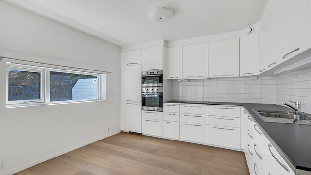Kjøkkenet har rikelig med skap- og benkeplass og plass til en sittegruppe