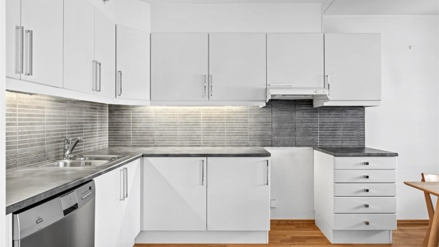 Kjøkken med innredning i profilerte fronter, benkeplate av laminat. Godt med skap og benkeplass