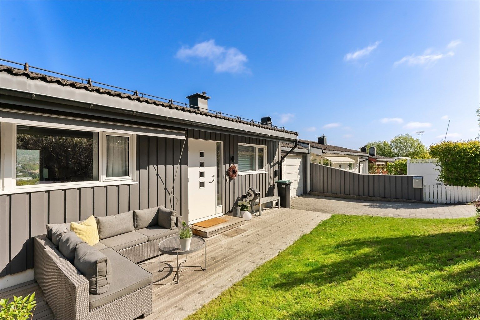 Boligen har flotte uteplasser med platting ved inngangspartiet, veranda ved kjøkkenet og terrasse i underetasjen