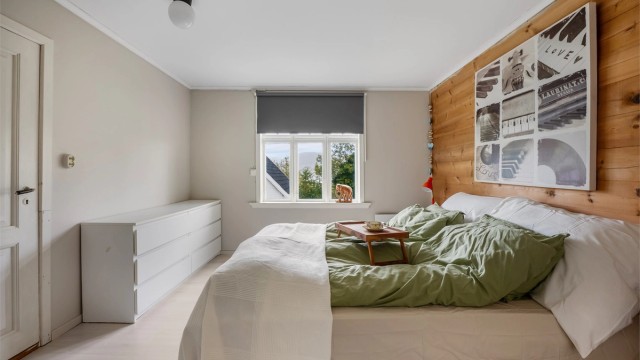Soverom i 2. etasje med panelvegg og god plass til dobbeltseng og kommode.