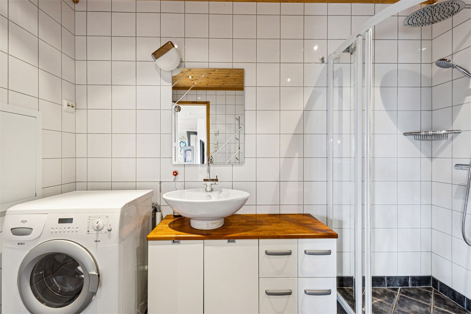 Servantmøbel med skuffer og speil med integrert belysning.
