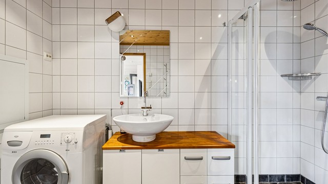 Servantmøbel med skuffer og speil med integrert belysning.