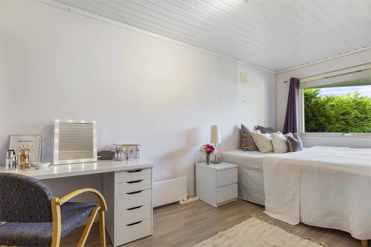 Soverom 1 med laminat på gulv, malt strietapet på vegger og malt panel i himling.