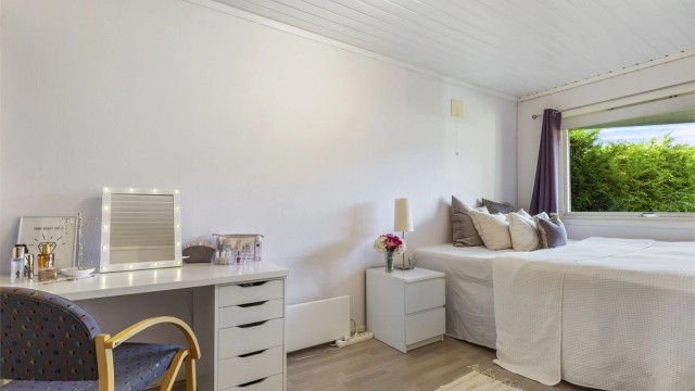 Soverom 1 med laminat på gulv, malt strietapet på vegger og malt panel i himling.