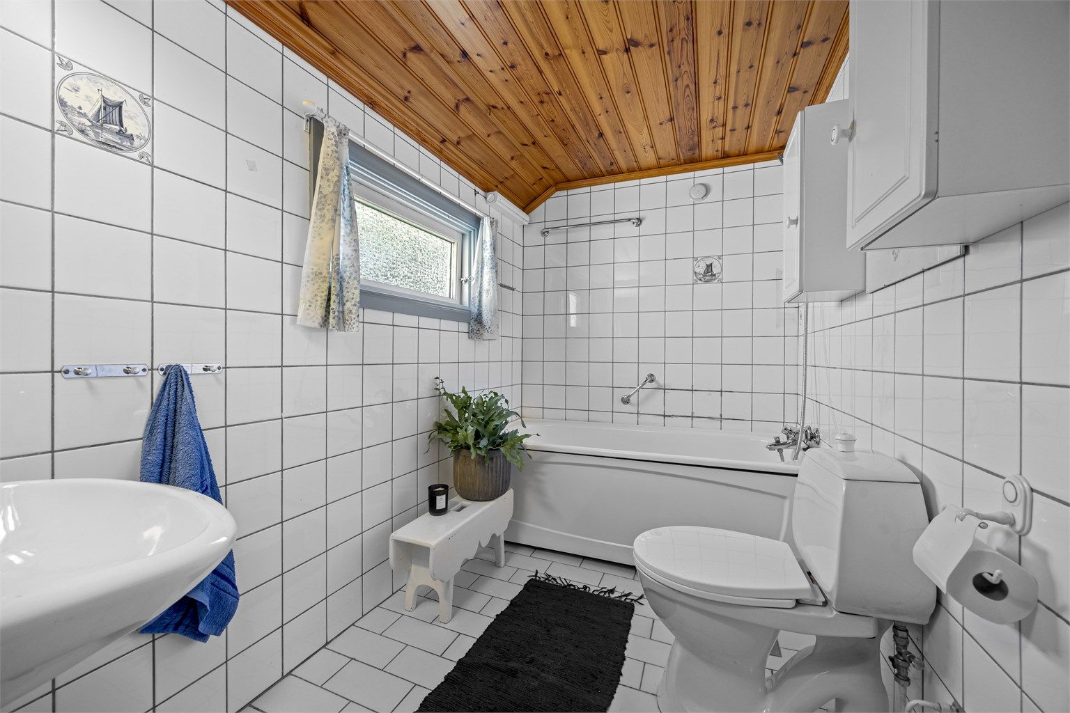 Badet i første etasje er fra 1985/86 og har flislagt gulv med gulvvarme, flislagte vegger og badekar.
