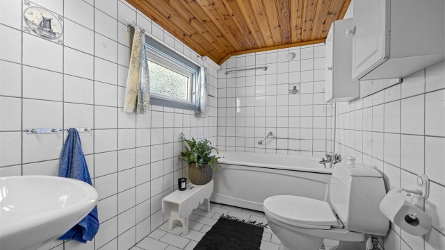 Badet i første etasje er fra 1985/86 og har flislagt gulv med gulvvarme, flislagte vegger og badekar.