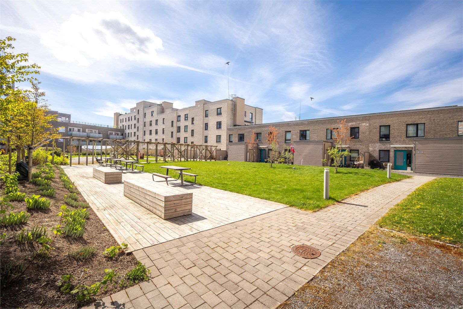 Fellesområdene er pent opparbeidet med gressplen, sittegrupper og beplantning.