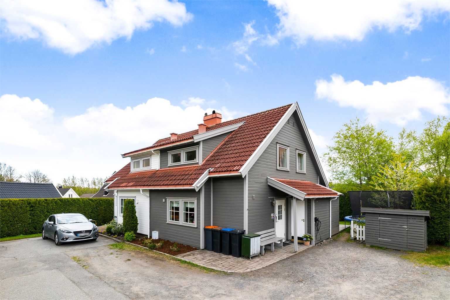 Gruset gårdsplass med plass til flere biler. 