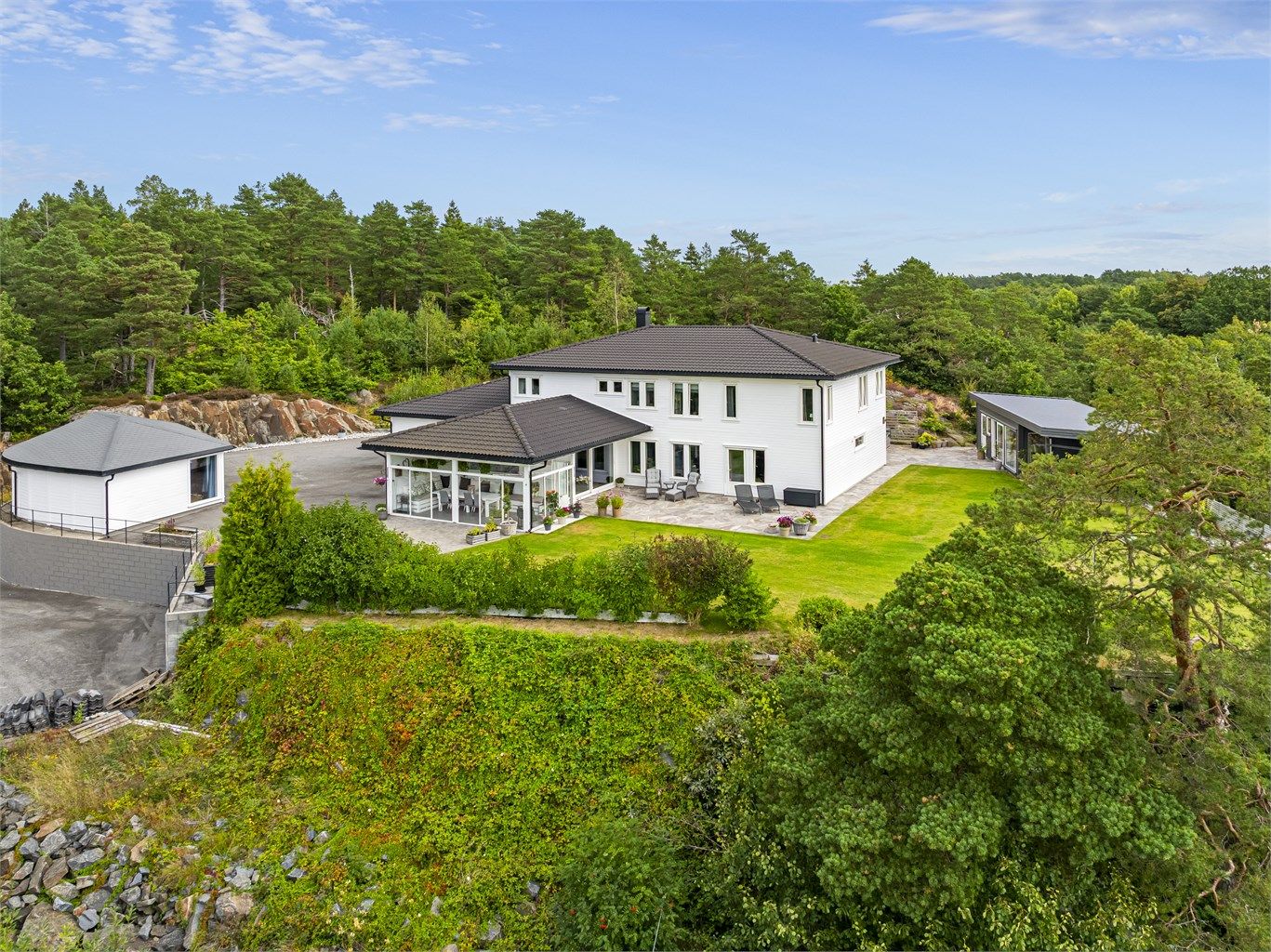 Eneboligen ligger alene på en liten høyde- her er det ingen gjennomgangstrafikk! Noen av vinduene (solutsatte) har utvendig solskjerming med screens. 