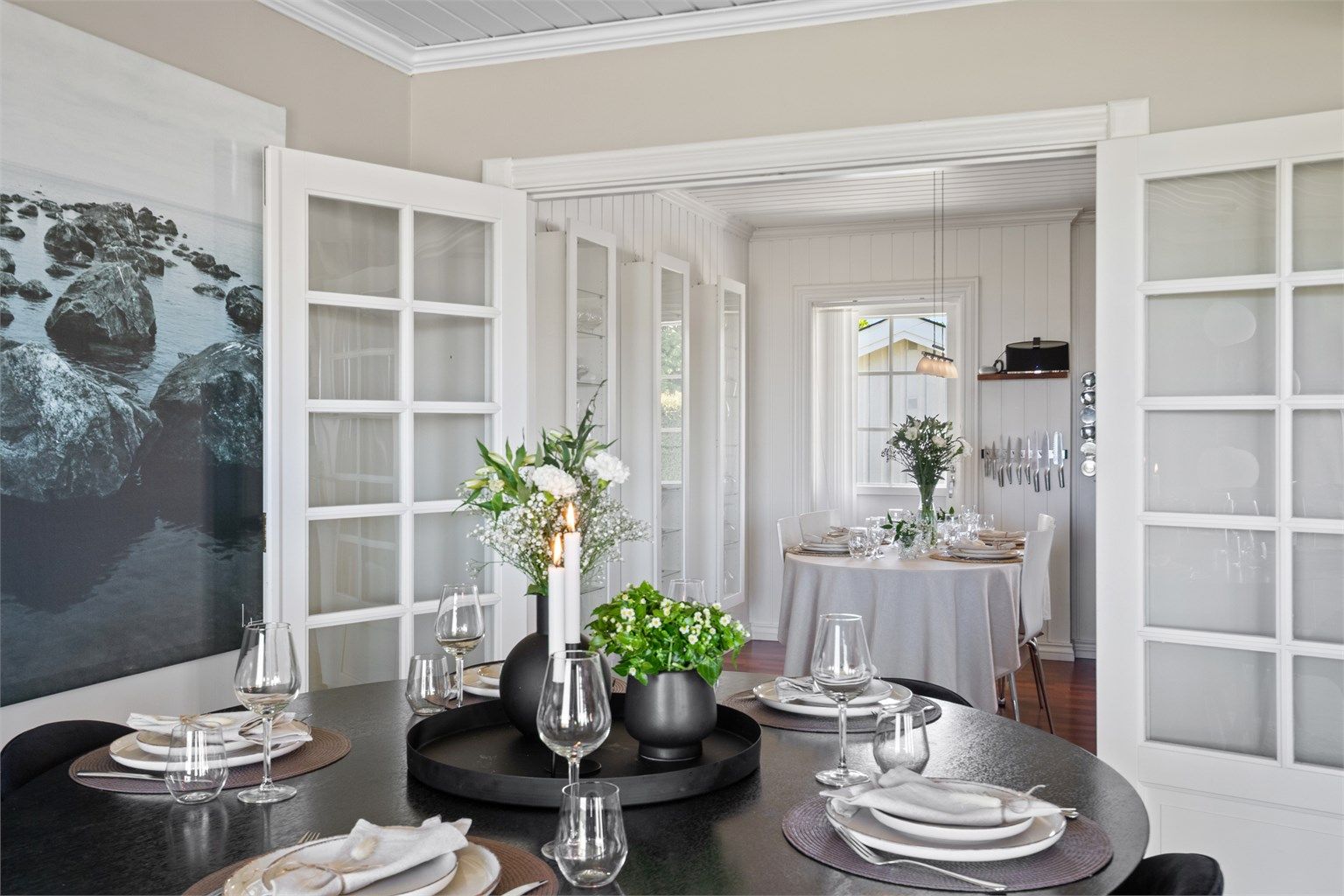 Tofløyede dører leder inn til kjøkkenet, og det er ellers åpent mot gangen. 