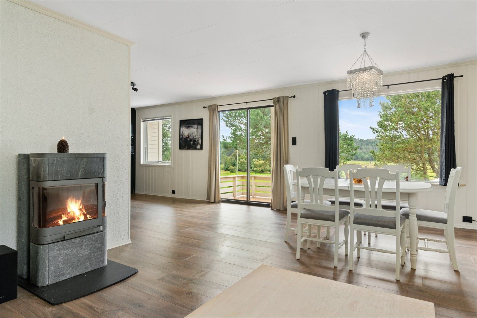 Stue med lyse overflater og godt med naturlig lysinnslipp fra store vindusflater