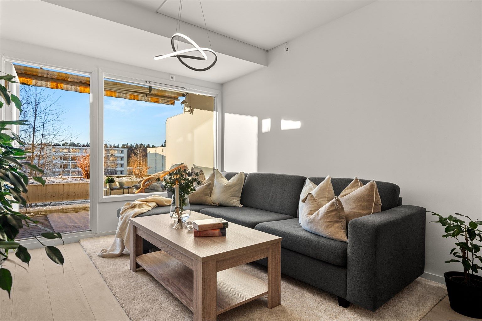 Romslig stue med god plass til sofaseksjon, stuebord og tilhørende mediemøblement.