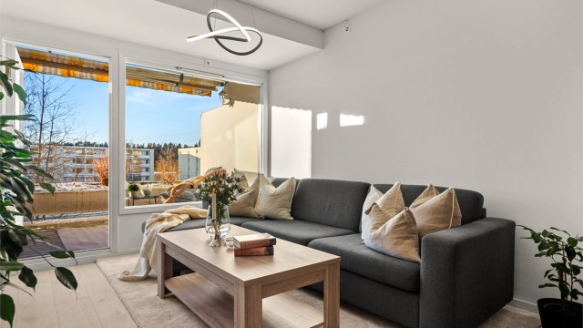 Romslig stue med god plass til sofaseksjon, stuebord og tilhørende mediemøblement.