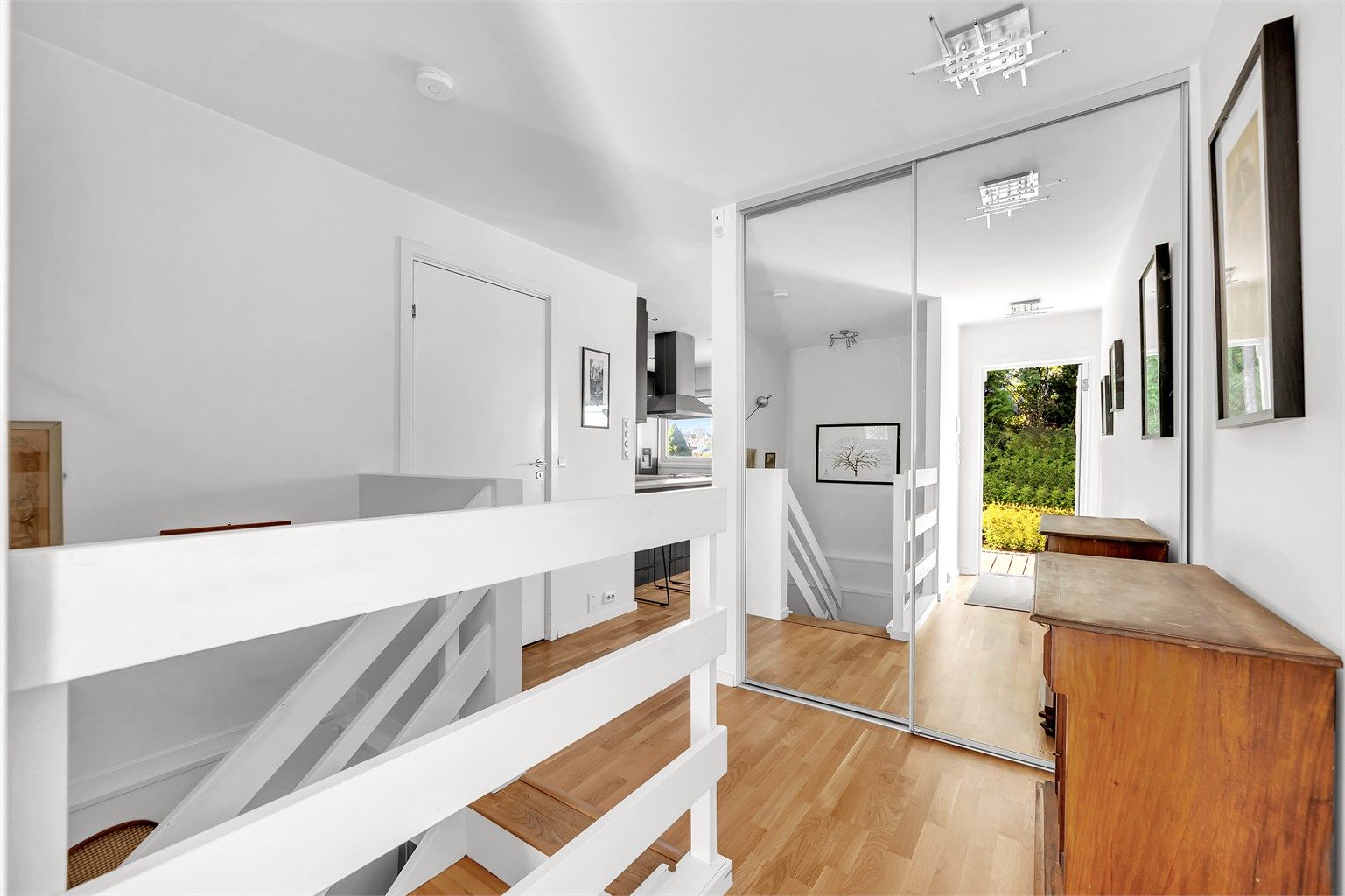 Romslig entré med skyvedørsgarderobe.