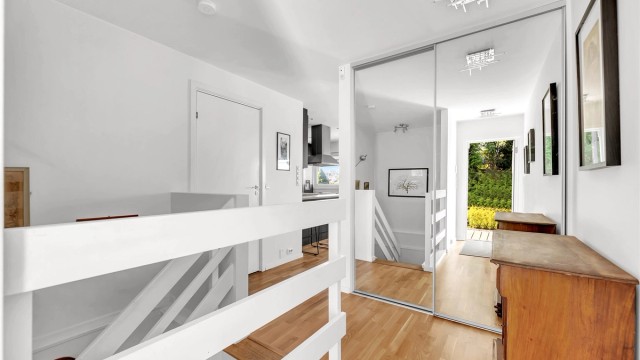 Romslig entré med skyvedørsgarderobe.