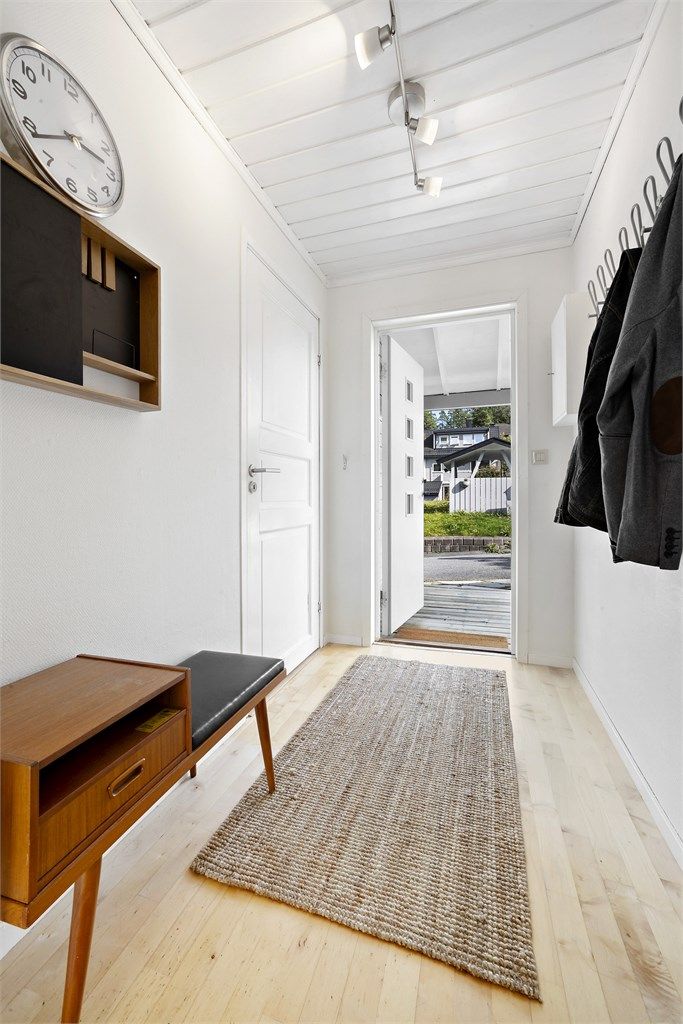 Man kommer inn i en romslig entré med knaggrekker