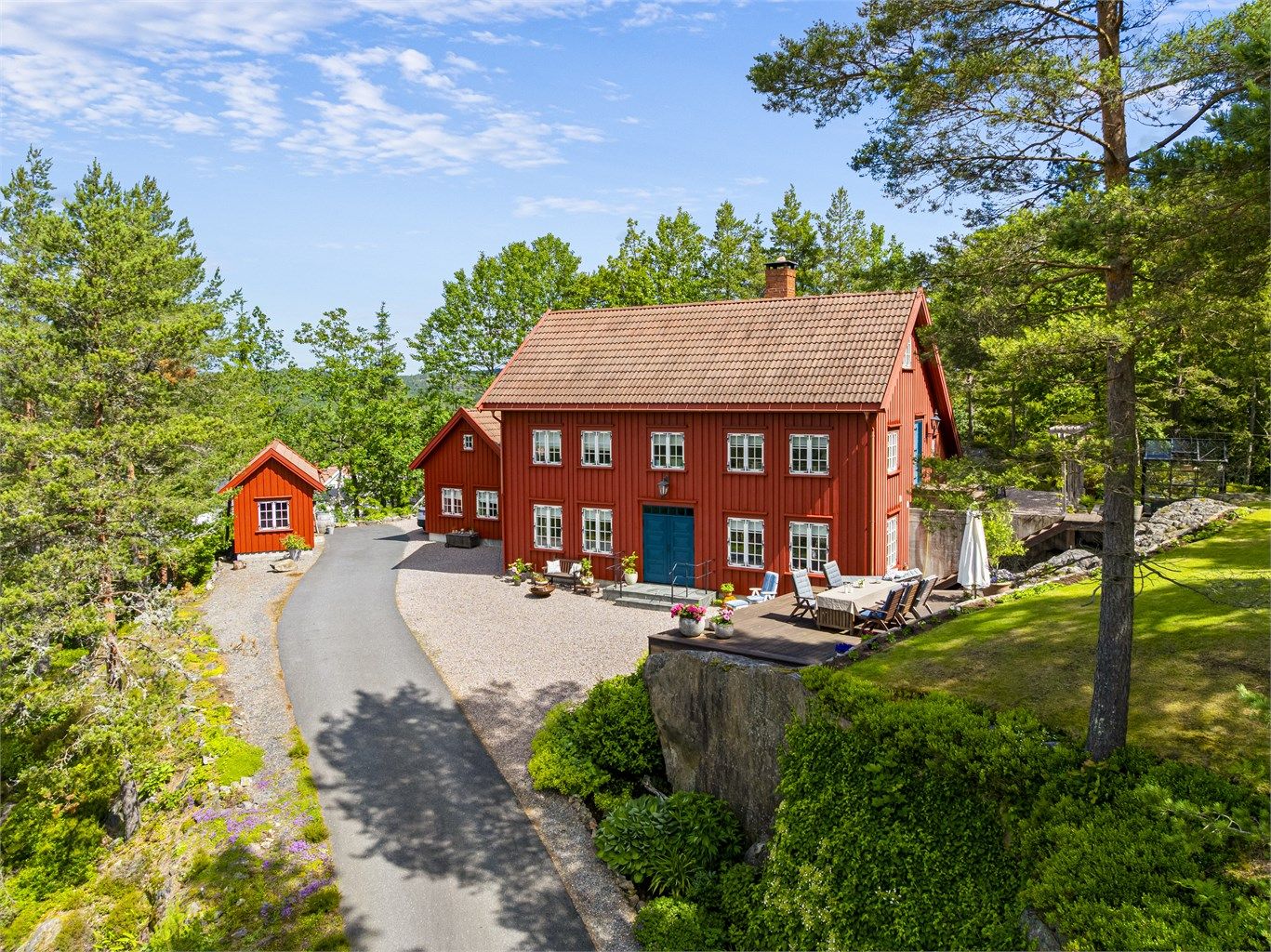 Oversikt over den romslige eiendommen med hovedhus og sidebygninger.