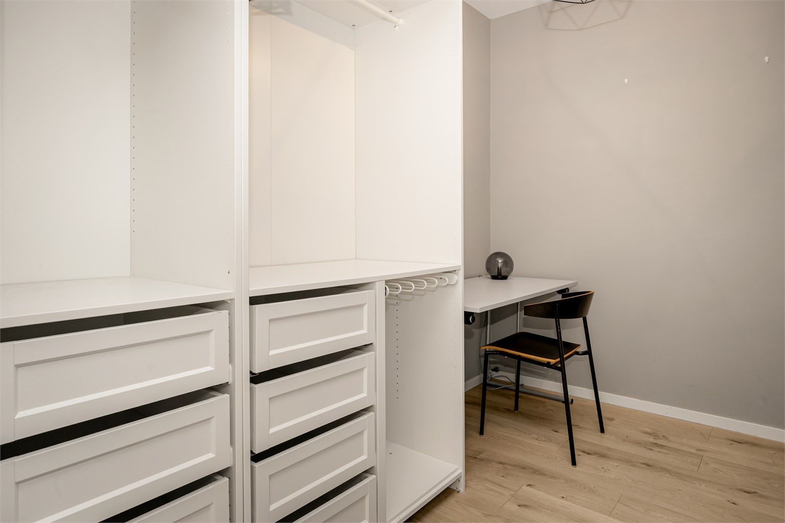 Innvendig bod med garderobeløsning - To åpne garderobeskap i hvit og profilert utførelse