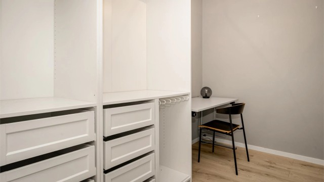 Innvendig bod med garderobeløsning - To åpne garderobeskap i hvit og profilert utførelse