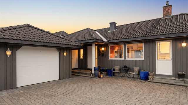 Parkering i frittstående garasje med elektrisk portåpner (garasjeport skiftet i 2021).