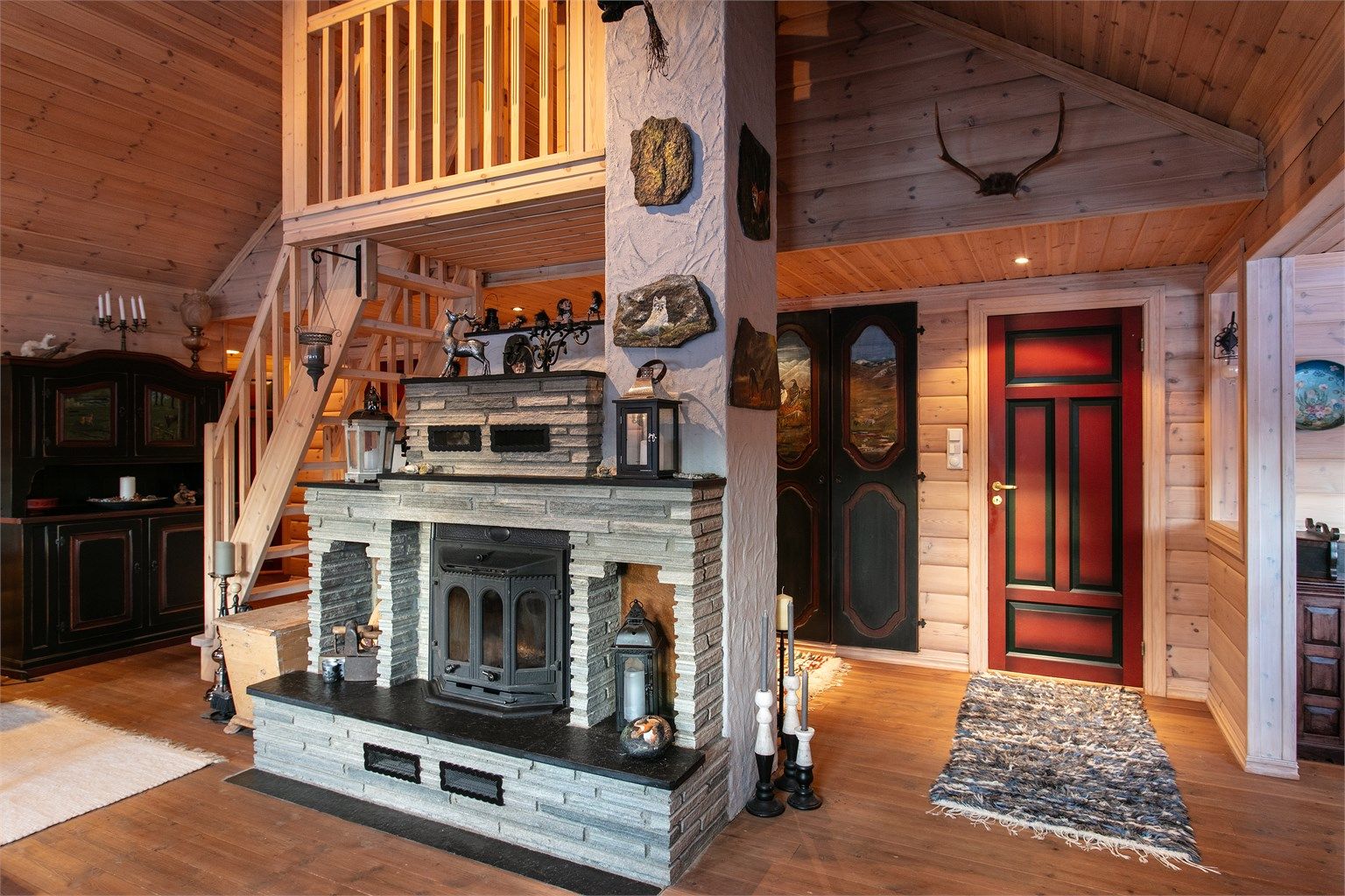 Flott murt peis med skiferstein midt i stuen som gir en lun og hyggelig atmosfære