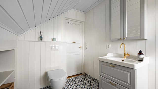 Badet er smakfullt innredet og passer godt til resten av huset. Legg merke til alle elementene med armatur og håndtak i messing.