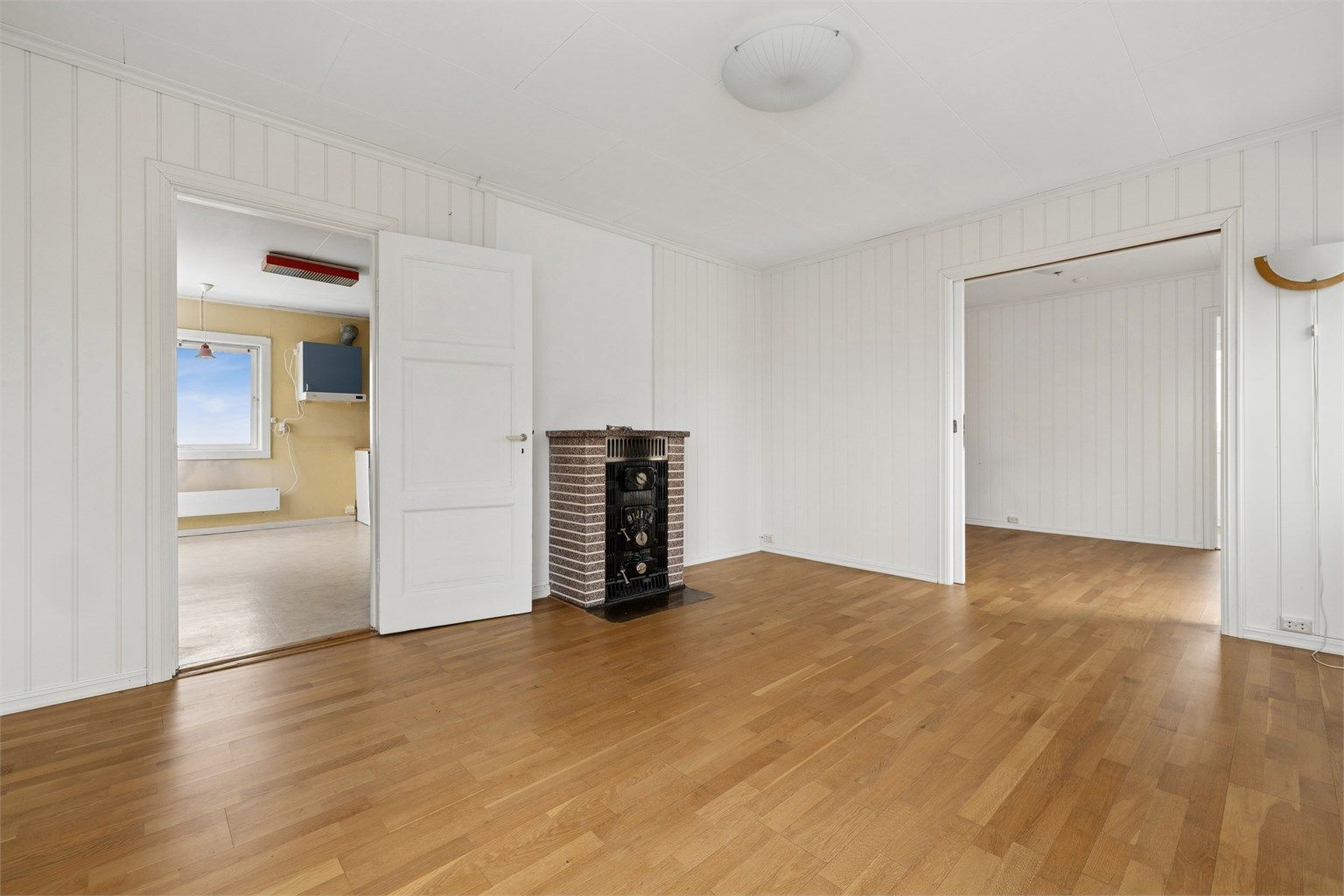 En vedovn av steinmateriale og støpejern er et sentralt element i stuen.