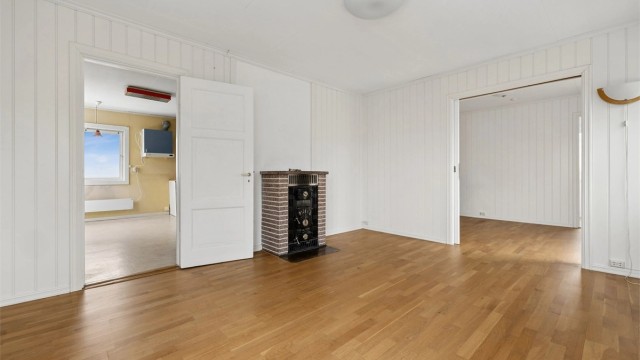 En vedovn av steinmateriale og støpejern er et sentralt element i stuen.