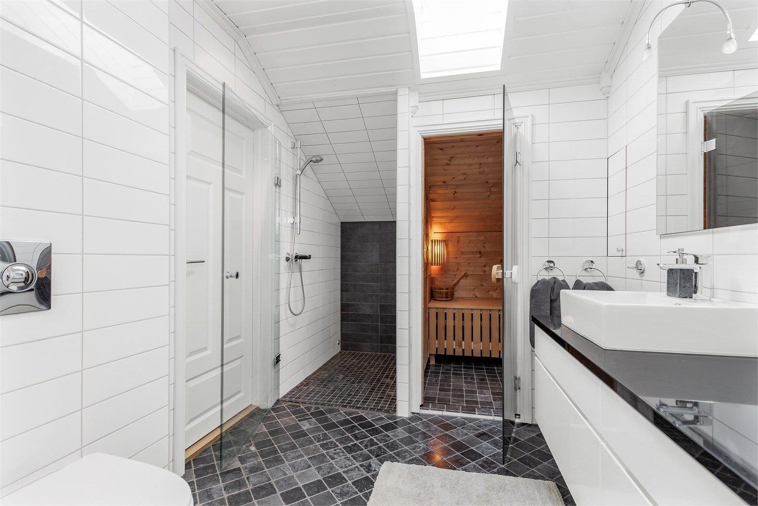 Dusjhjørne med dør. Vegghengt dusjarmatur. Vegghengt toalett. Mekanisk avtrekk med ventil i himling.