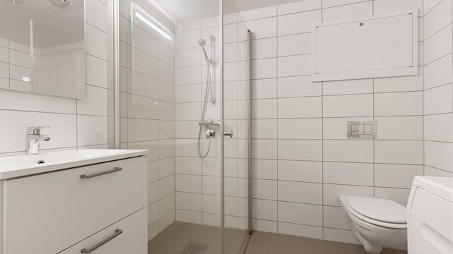 Flislagt bad med foldedører i dusjen