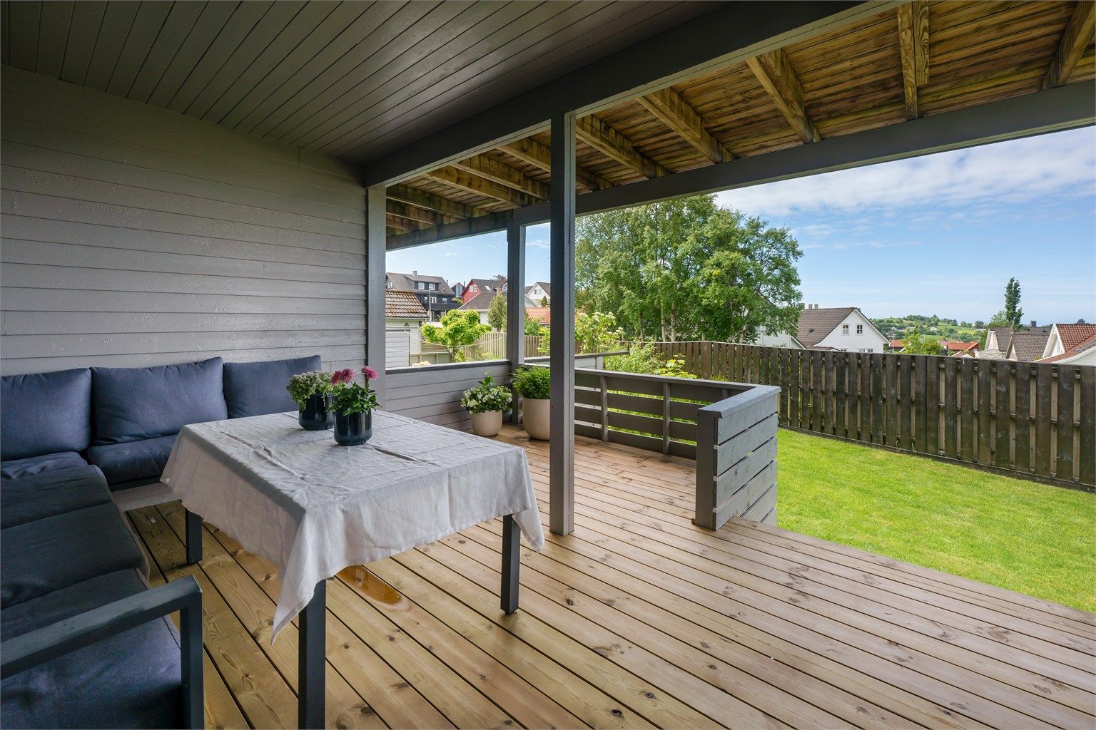 Overbygd terrasse med tilgang til hagen.