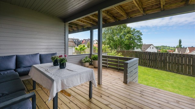 Overbygd terrasse med tilgang til hagen.