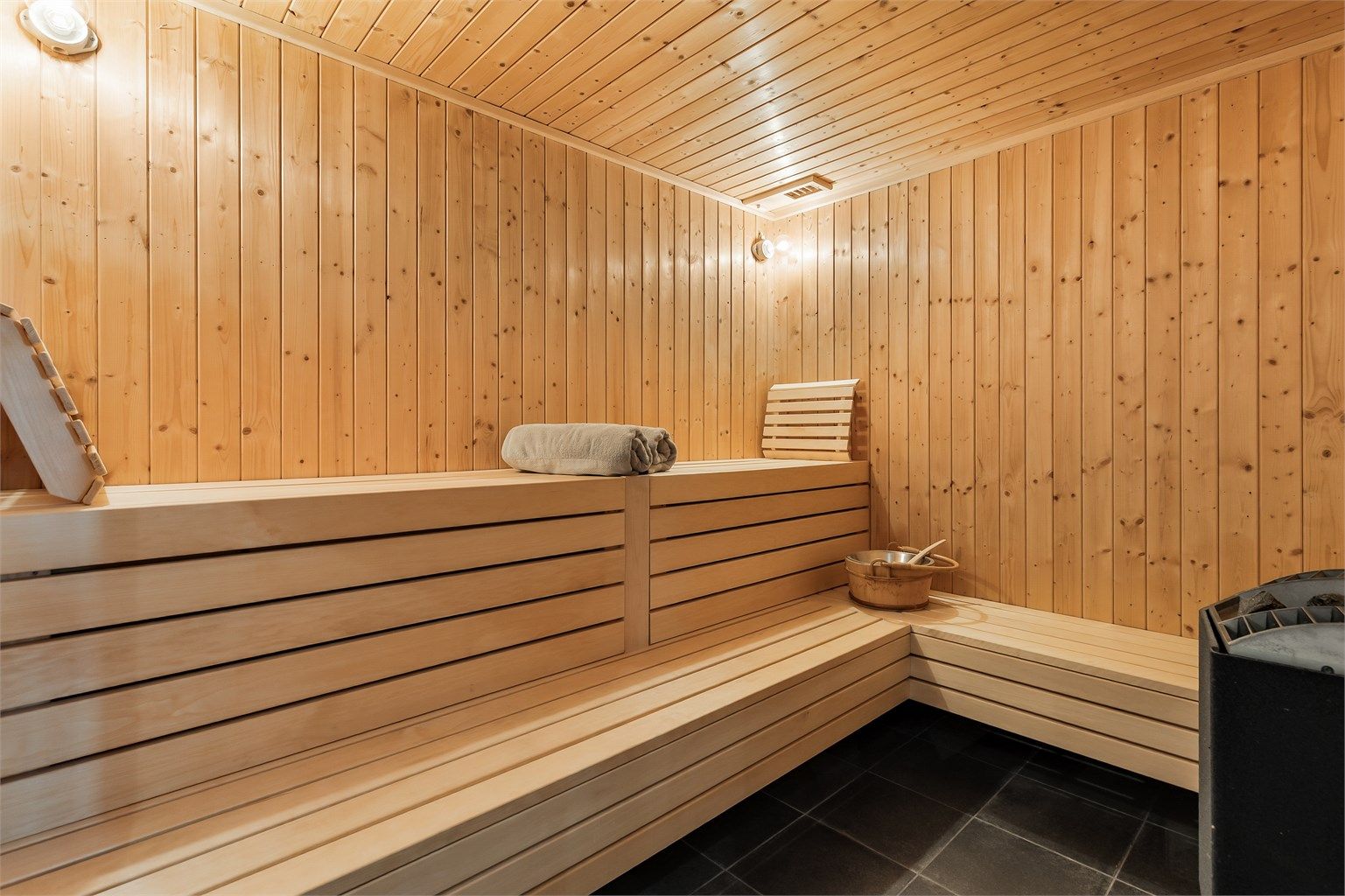 Romslig badstue med flislagt gulv. Panel på vegger. Panelbord i himling. Elektrisk badstueovn.