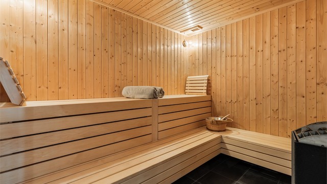 Romslig badstue med flislagt gulv. Panel på vegger. Panelbord i himling. Elektrisk badstueovn.