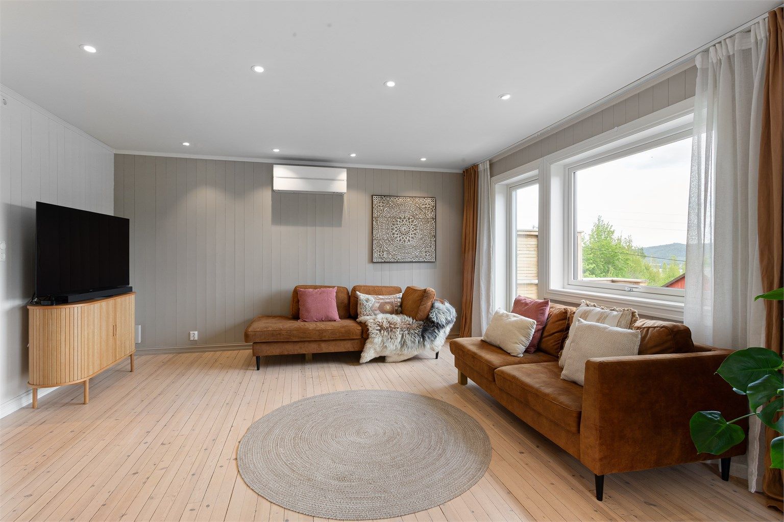 Fin stue med plass til sofagruppe. Downlights i himlingen.