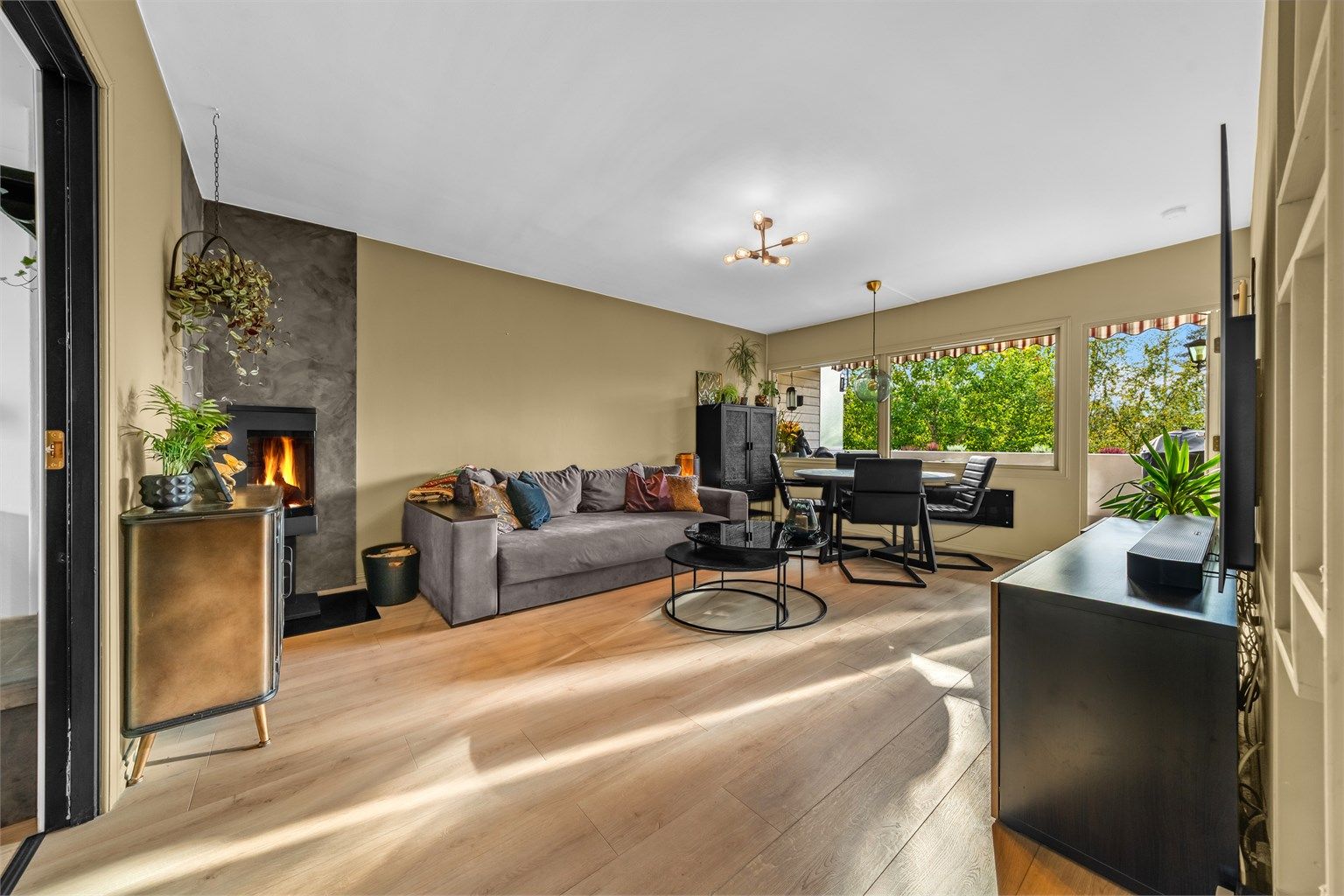 Stuen har en tidsriktig og rentbrennende peisovn fra Nordpeis i hjørnet

