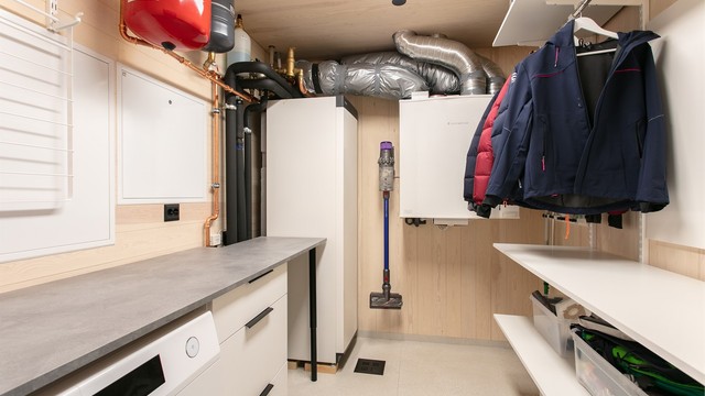 Praktisk vaskerom med væske-til-vann-varmepumpe og opplegg for vaskemaskin.