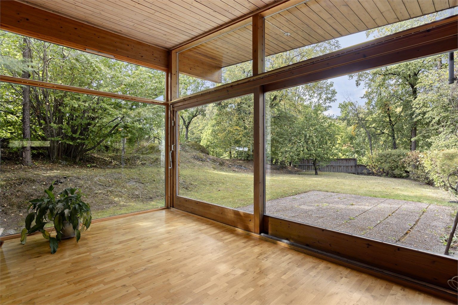 Store vindusflater i stuen med utgang til hage og uteplass.