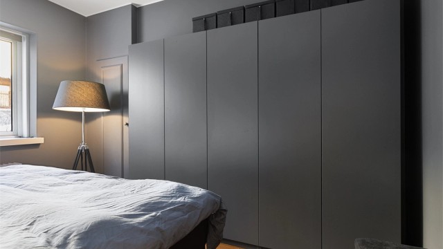 En hel vegg med garderobeskap samt tilgang til et kott gir rikelig med oppbevaringsplass.