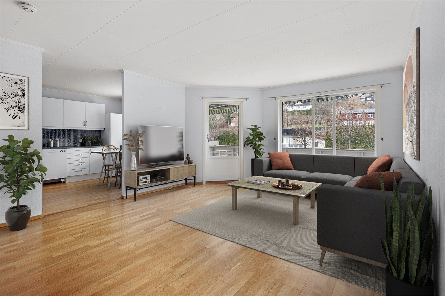 Lys og åpen stue med delvis åpen løsning mot kjøkken.