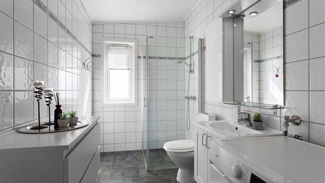 Baderomsinnredningen inkluderer en servant og speil med overlys.